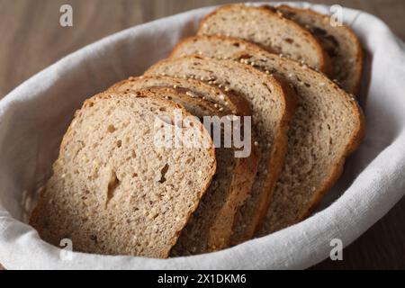 Tranches de pain frais sur un chiffon dans le panier, gros plan Banque D'Images