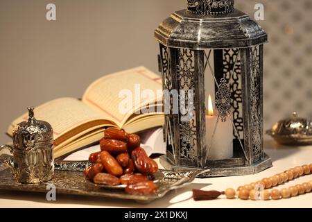 Lanterne arabe, Coran, misbaha et dates sur table blanche Banque D'Images