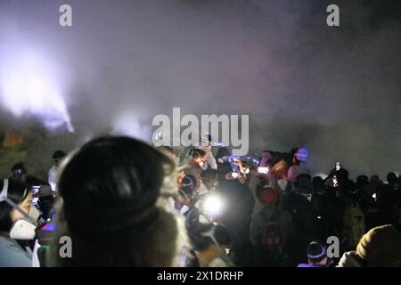 Mont Ijen, Java en Indonésie - 04 février 2024 : les gens marchent la nuit vers le feu bleu dans le cratère du volcan Banque D'Images