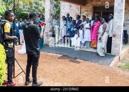 La famille élégamment habillée pose pour un portrait après le mariage dans l'étreinte de la nature. Les femmes ornent des robes colorées, les costumes de sport pour hommes avec des cravates, tandis que les enfants aussi Banque D'Images