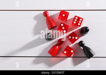 Dés de jeu rouges et pièces sur table en bois blanc, pose à plat. Espace pour le texte Banque D'Images