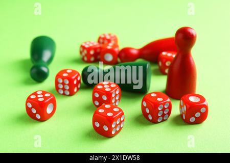 Beaucoup de dés rouges et de pièces de jeu de couleur sur fond vert Banque D'Images