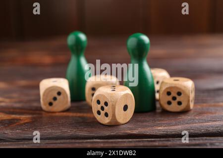 Beaucoup de dés et de pièces de jeu vertes sur la table en bois, gros plan Banque D'Images