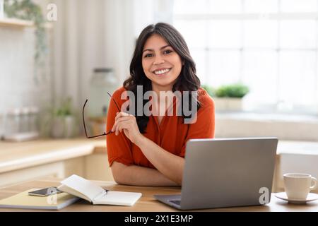Femme souriante avec ordinateur portable au bureau à domicile Banque D'Images