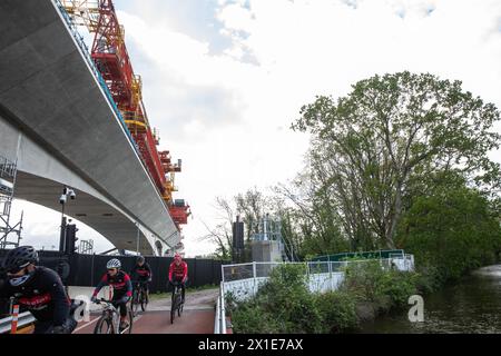 Hillingdon, Royaume-Uni. 16 avril 2024. Les cyclistes passent sous le viaduc en partie construit de Colne Valley pour la liaison ferroviaire à grande vitesse HS2 et le long du Grand Union canal. Le viaduc transportera HS2 à travers les lacs et les cours d’eau du parc régional de Colne Valley. Crédit : Mark Kerrison/Alamy Live News Banque D'Images