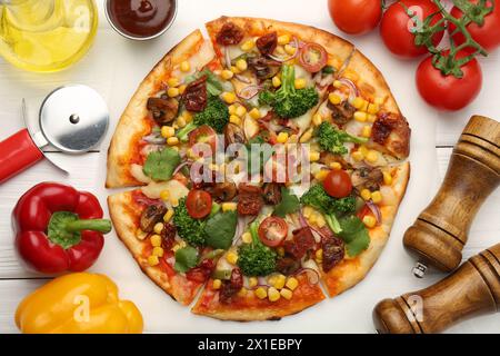 Délicieuse pizza végétarienne servie sur une table en bois blanc, plat Banque D'Images