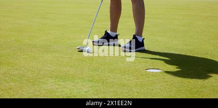 Le golfeur s'entraîne sur le putting green, à la première lumière du matin. Banque D'Images