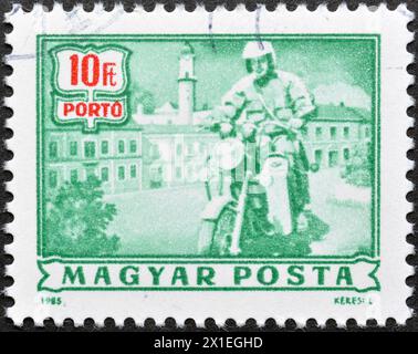 Timbre-poste annulé imprimé par la Hongrie, qui montre Postage due - postier à moto, vers 1985. Banque D'Images