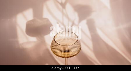 Deux verres avec du vin blanc placés sur fond beige clair avec des ombres Banque D'Images