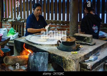 Mère et fille cuisinant une tortilla de maïs sur un poêle plat traditionnel. Oaxaca, Mexique. Banque D'Images