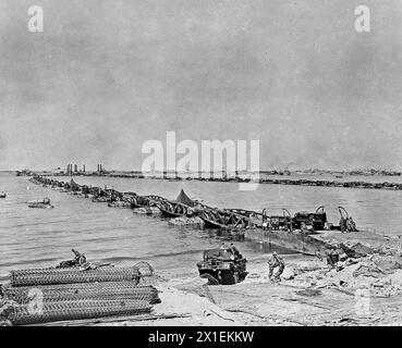 Légende originale : « ces plates-formes d'atterrissage improvisées, s'étendant dans le chenal depuis Omaha Beach, en France, seront utilisées pour recevoir de grandes quantités de matériel provenant d'embarcations de débarquement pour le transfert vers le continent. » env. 23 juin 1944 Banque D'Images