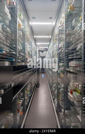 Photographie d'une salle de stockage de pharmacie et une main de robot arrangent et stockent des médicaments dans une pharmacie. Banque D'Images