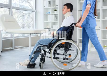 Jeune homme blessé en fauteuil roulant après un accident avec le médecin à l'hôpital Banque D'Images