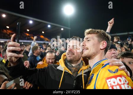 Elliott Hewitt de Mansfield Town et ses fans célèbrent leur promotion en Sky Bet League One après le match Sky Bet League Two au One Call Stadium de Mansfield. Date de la photo : mardi 16 avril 2024. Banque D'Images