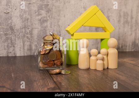 Gros plan petite petite maison de jouet en bois sur la table, toute la grande famille de maman, papa, grand-mère et grand-père assis ensemble sur le canapé dans le salon en b flou Banque D'Images