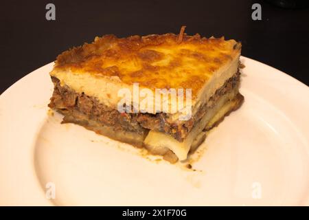 Laissez-vous tenter par la riche tradition culinaire de la Méditerranée avec cette assiette alléchante de moussaka. Couches d'aubergines tendres, viande hachée salée, et c Banque D'Images