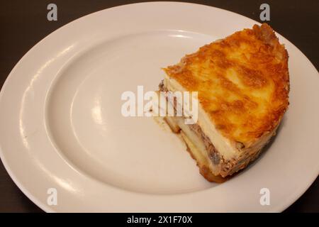 Laissez-vous tenter par la riche tradition culinaire de la Méditerranée avec cette assiette alléchante de moussaka. Couches d'aubergines tendres, viande hachée salée, et c Banque D'Images