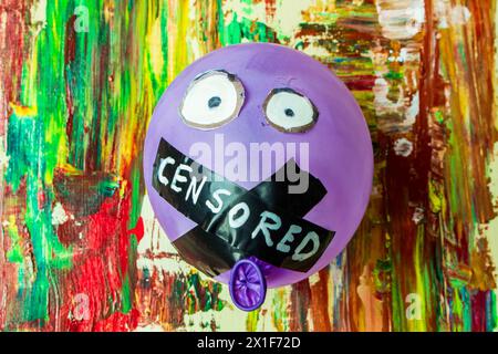 Dans une juxtaposition vivante de couleur et de contrainte, voici cette image symbolique représentant un ballon dont la bouche est scellée, suspendu contre un dos Banque D'Images