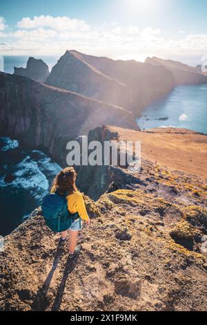 Description : vue de dessus d'une femme routard regardant d'une vue panoramique matinale sur les contreforts d'une île dans l'océan Atlantique. São Louren Banque D'Images