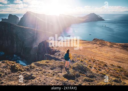 Description : vue arrière d'un touriste routard enjouant vue sur les contreforts d'une île dans l'océan Atlantique. São Lourenço, île de Madère, Portu Banque D'Images