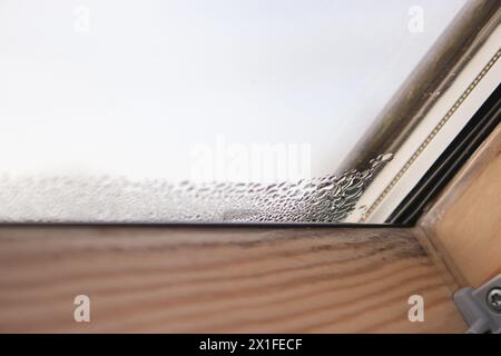 Gros plan de la condensation sur la fenêtre velux dans une maison, des gouttes d'eau et de l'humidité élevée Banque D'Images