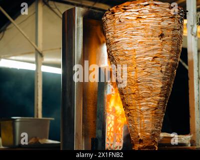Griller la viande de porc traditionnelle trompo al Pastor Street taco à la broche avec des flammes la nuit au Mexique. Banque D'Images