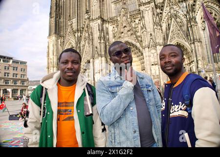 Cologne, Allemagne, 12 avril 2024. Trois Africains posent pour une photo de groupe devant le Dôme de Cologne. Banque D'Images