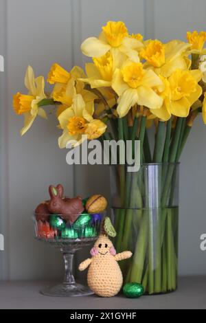 Bouquet de jonquilles dorées dans un vase en verre sur fond de bois vert avec espace pour le texte. Banque D'Images