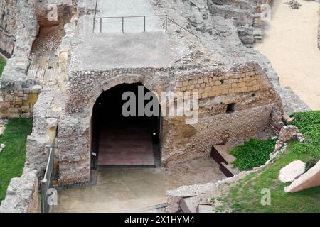 Vue sur l'entrée d'un ancien amphithéâtre romain à Tarragone, mettant en valeur l'architecture robuste et la beauté naturelle environnante. Un aperçu de Banque D'Images