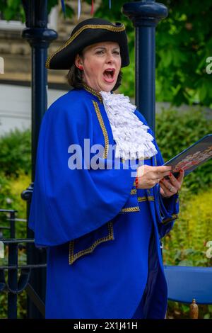 Les vêtements bleus de la femme crier de la ville) proclamant oyez, faisant une proclamation publique forte et annonce - Ilkley, West Yorkshire, Angleterre, Royaume-Uni. Banque D'Images