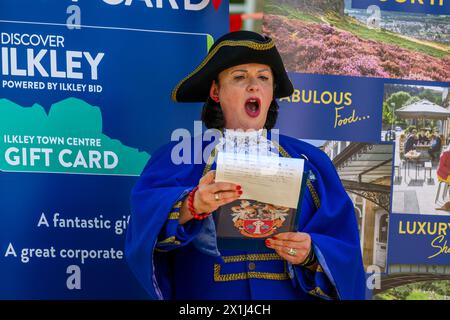 Les vêtements bleus de la femme crier de la ville) proclamant oyez, faisant une proclamation publique forte et annonce - Ilkley, West Yorkshire, Angleterre, Royaume-Uni. Banque D'Images