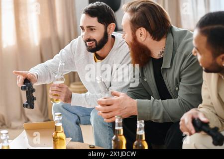 Trois hommes joyeux et interraciaux apprécient un rassemblement décontracté, riant et bavardant autour de bouteilles de bière sur une table. Banque D'Images
