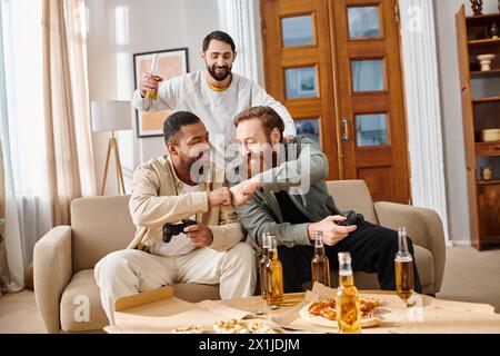 Trois beaux hommes interraciaux en tenue décontractée s'assoient joyeusement autour d'une table avec de la bière, partageant rire et camaraderie. Banque D'Images