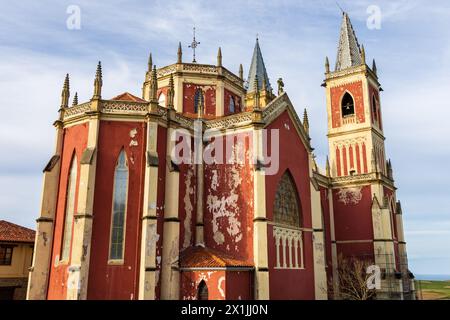 L'église paroissiale rouge vif de San Pedro ad Venceya, avec deux tours, dans le néo-gothique français et l'Indiano. Cóbreces, Cantabrie, Espagne. Banque D'Images