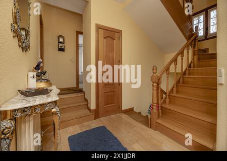 Escalier intérieur en bois dans une maison avec des meubles en bois, menuiserie en chêne sur les portes et les garde-corps du même matériau Banque D'Images