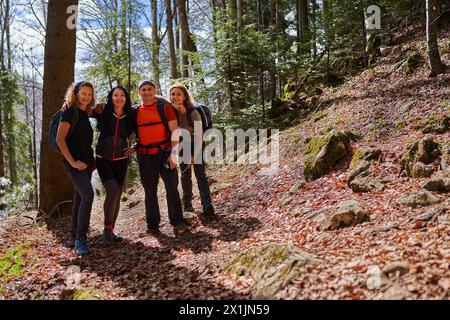 Groupe mixte de randonneurs avec un homme et trois femmes avec des sacs à dos sur un sentier dans les hautes terres Banque D'Images