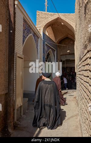 Des hommes iraniens portant des vêtements religieux musulmans traditionnels marchent dans une ruelle étroite du Grand Bazar d'Ispahan, en Iran. Banque D'Images