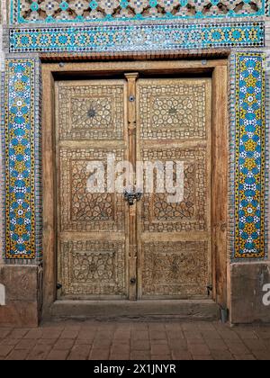 Vieille porte en bois fermée recouverte de sculptures complexes dans la mosquée Jameh d'Ispahan, l'une des plus anciennes mosquées d'Iran. Ispahan, Iran. Banque D'Images