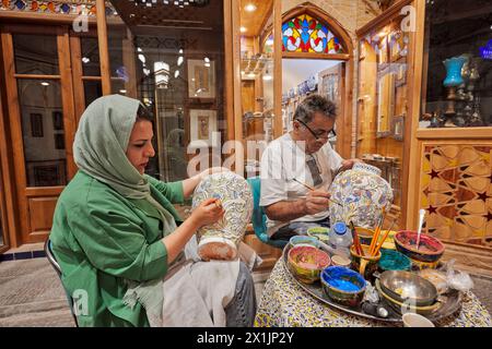 Les artisans iraniens peignent à la main de grands pots en céramique avant le vitrage final. Grand Bazar, Ispahan, Iran. Banque D'Images