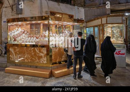 Les gens regardent des bijoux en or exposés dans une petite vitrine dans le Grand Bazar d'Ispahan, en Iran. Banque D'Images