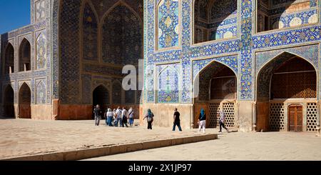 Un groupe de touristes se promène dans la cour de la mosquée Shah (Masjed-e Shah). Ispahan, Iran. Banque D'Images