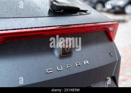 Kiev, Ukraine. Avril 2024. Le logo Seat Cupra sur une voiture en gros plan gris avec des gouttes d'eau. Banque D'Images