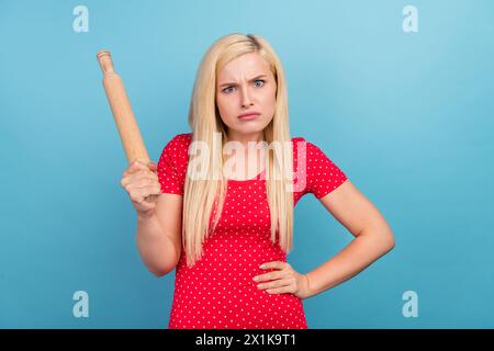 Portrait photo femme au foyer argumentant malheureuse en gardant le rouleau à pâtisserie isolé fond de couleur bleu pastel Banque D'Images