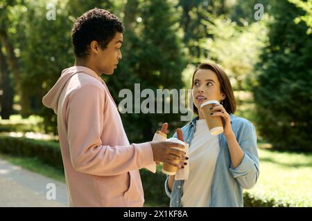 Un couple dans une tenue vibrante s'engage dans une conversation animée à l'extérieur, entouré par la beauté de la nature. Banque D'Images