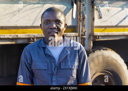 jeune conducteur africain en vêtements de travail, à côté du camion Banque D'Images