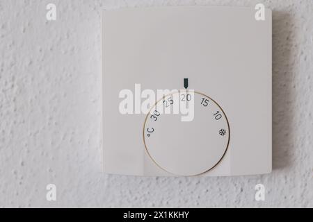 Thermostat d'ambiance sur le mur en cours de réglage. Température 20 degrés Celsius sur un thermostat Banque D'Images