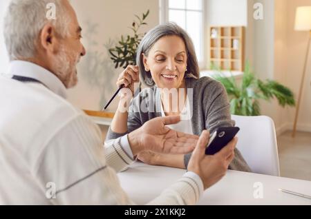 Couple de familles âgées utilisant le téléphone et rire ensemble Banque D'Images