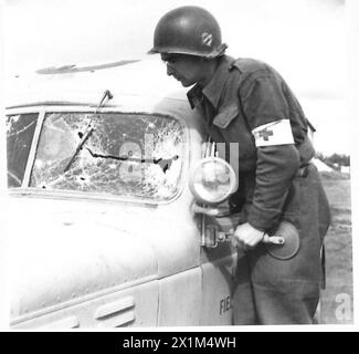 ITALIE : CINQUIÈME ARMYNURSES DANS LA TÊTE DE PONT ANZIO - chauffeur d'ambulance américain - volontaire Royal Fowler de Cornouailles, Conn, regarde ce qui restait de son pare-brise après avoir été tendu par des combattants ennemis, l'armée britannique Banque D'Images