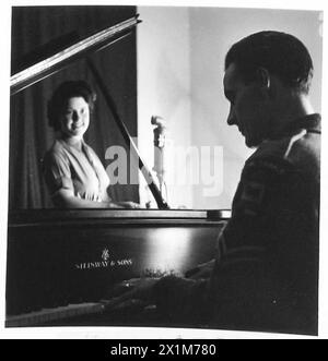 RÉSEAU DES FORCES BRITANNIQUES : HAMBOURG - angle de vue d'un pianiste et d'un chanteur en train d'auditionner ensemble. Le pianiste est le caporal Jack Crawford, Royal Signals, Barnstree, Jacobs Well, près de Guildford. Était un pianiste de danse professionnel avant la guerre et participera maintenant à Piano Playtime, qui est un élément du matin et est joué tous les jours par un membre différent, de l'un des services. Singer est soldat Townshend, armée britannique du Rhin Banque D'Images