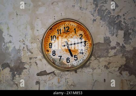 Vieille horloge murale rouillée cassée dans un bâtiment abandonné à Pripyat, zone d'exclusion de Chornobyl, Ukraine. Concept de flux de temps. Banque D'Images